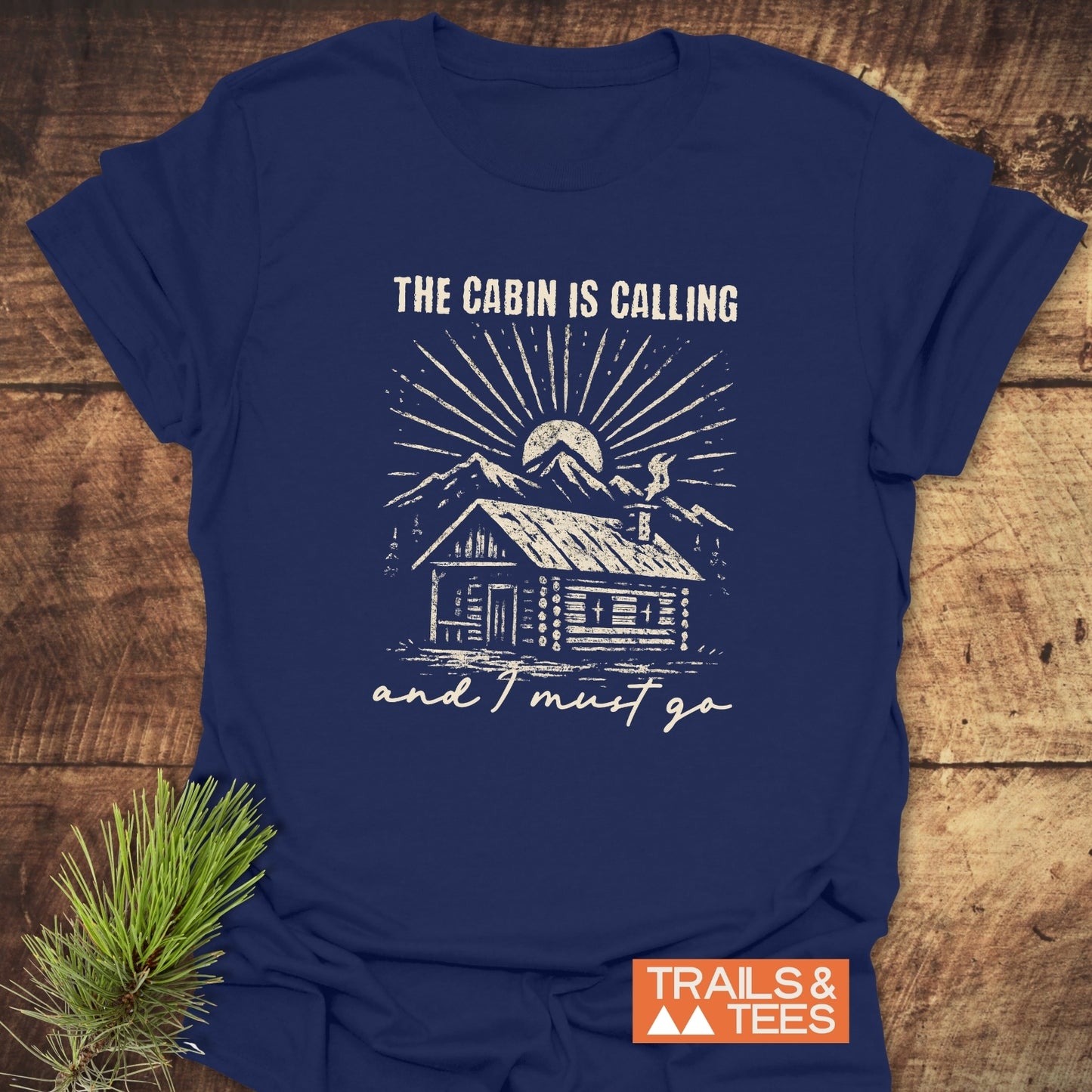 Navy-blue The Cabin Is Calling t-shirt featuring a rustic log cabin design, crafted from soft ring-spun cotton for comfort and durability.