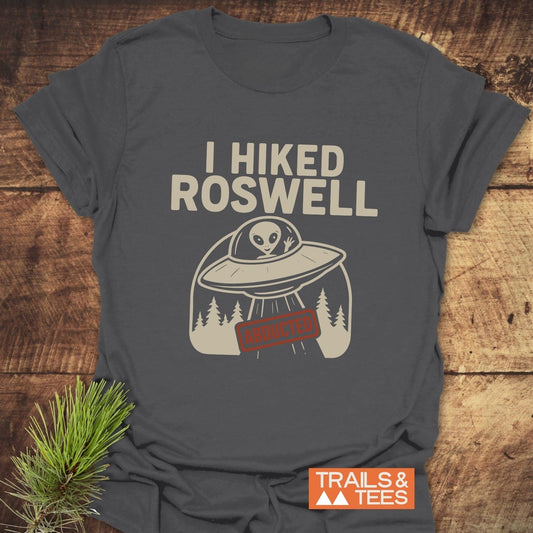 I Hiked Roswell T-Shirt featuring a flying saucer graphic and ABDUCTED label, crafted from soft cotton, ideal for outdoor enthusiasts.