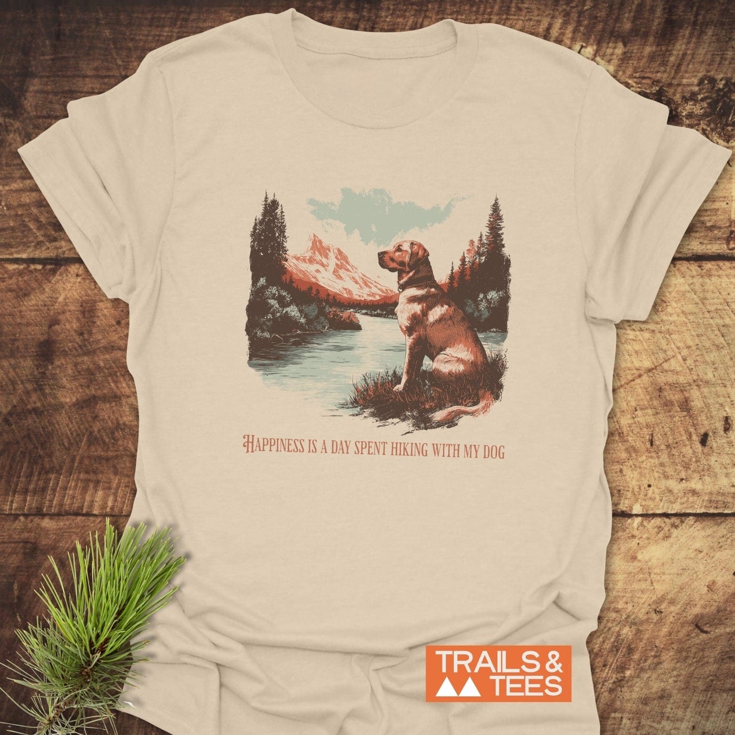 Happiness Is Hiking With Dogs T-Shirt showcasing a dog by a mountain lake. Features soft, lightweight ring-spun cotton, durable print, and no side seams.