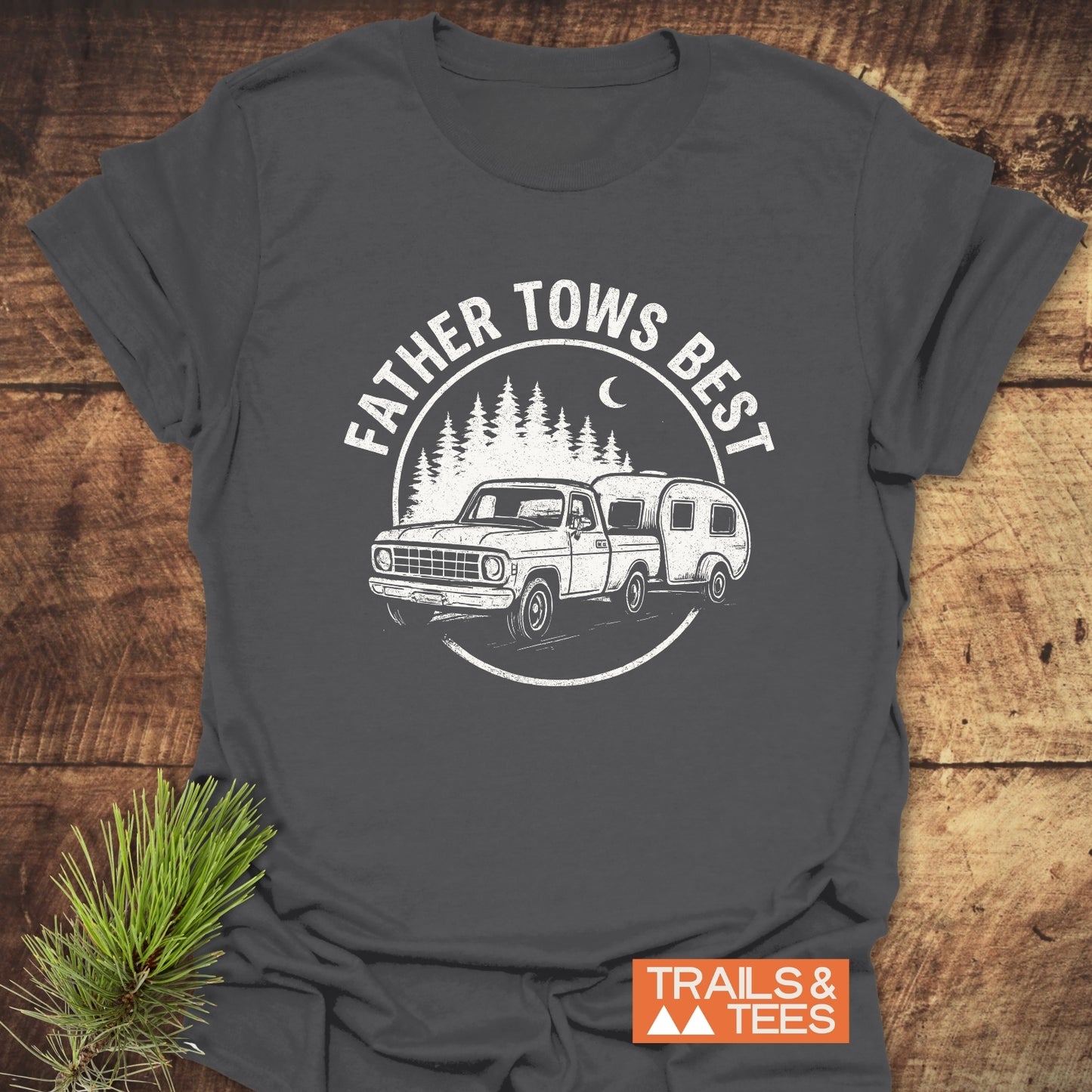 Father Tows Best T-Shirt: Dark-gray tee with vintage truck and camper graphic, pine trees, crescent moon, and slogan. Soft, pre-shrunk cotton for outdoor enthusiasts.