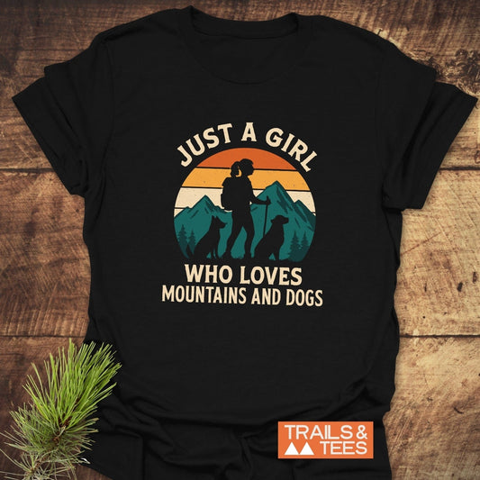 Mountains And Dogs T-Shirt featuring a retro graphic of a hiker with dogs and mountains, highlighting its soft cotton construction and durable print.