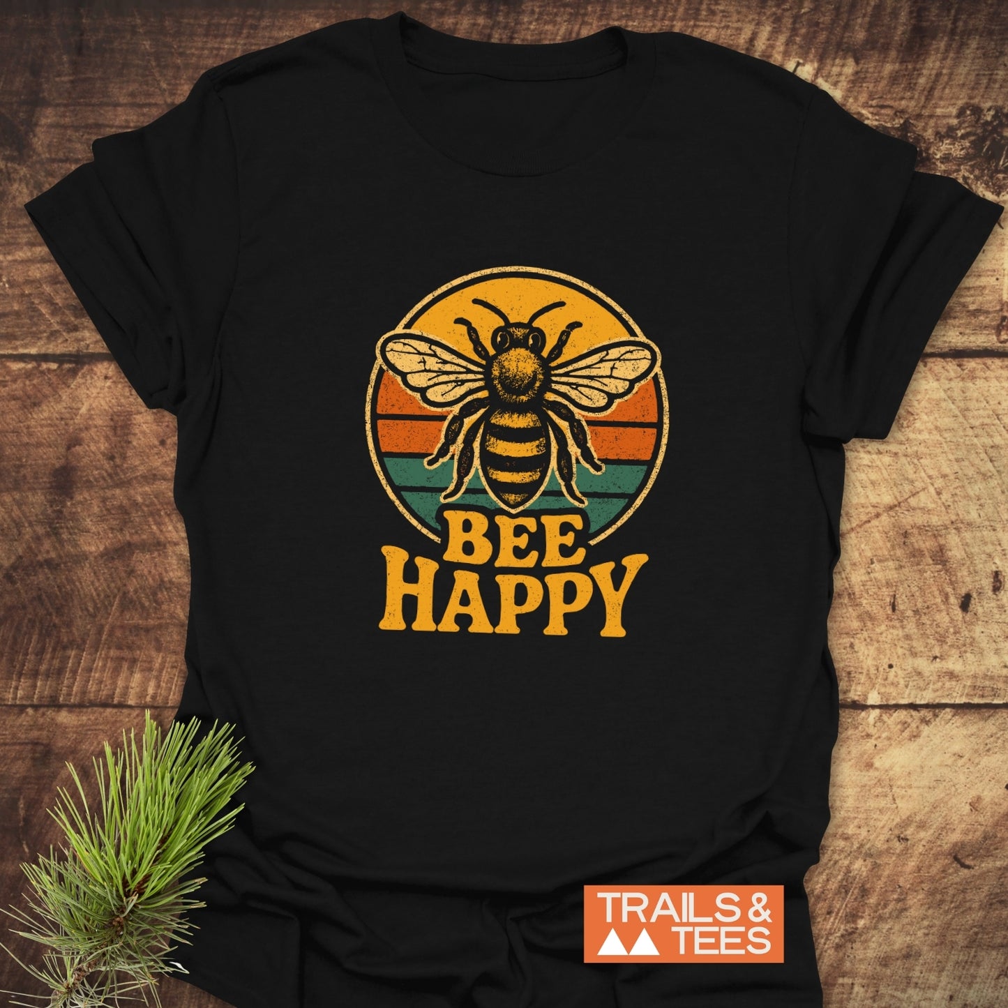 Bee Happy T-Shirt with vintage bee graphic on rustic surface; made from soft, ring-spun cotton, showcasing the Trails & Tees logo for outdoor enthusiasts.