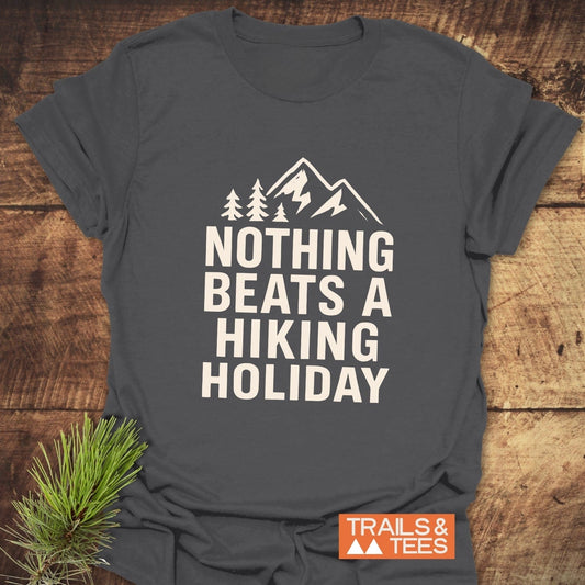 Nothing Beats A Hiking Holiday T-Shirt with mountain and pine tree graphic, featuring soft ring-spun cotton and durable print. Includes “TRAILS & TEES” logo.