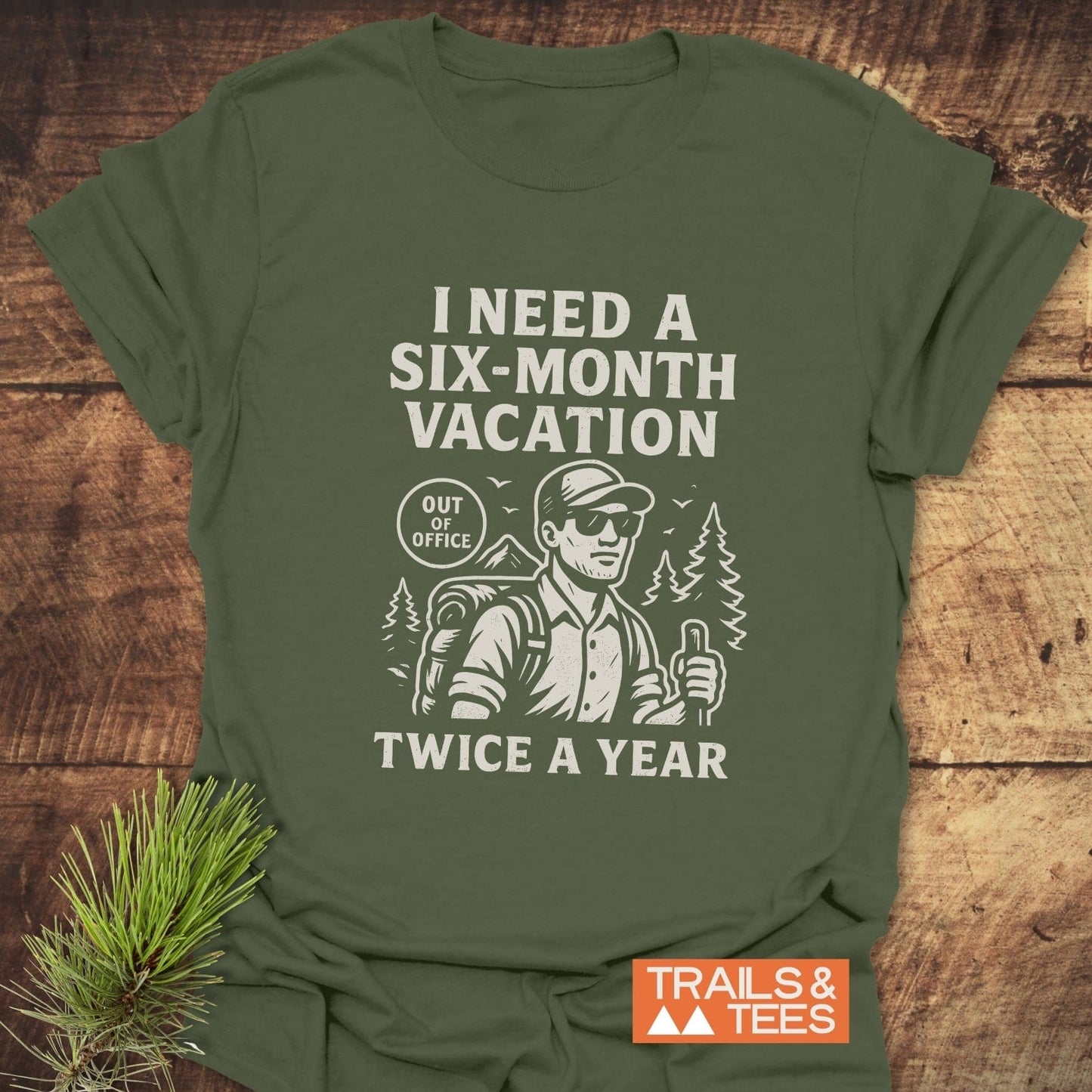 Six-Month Vacation T-Shirt with hiker illustration, “I NEED A SIX-MONTH VACATION” text, and “OUT OF OFFICE” badge; perfect for outdoor enthusiasts.