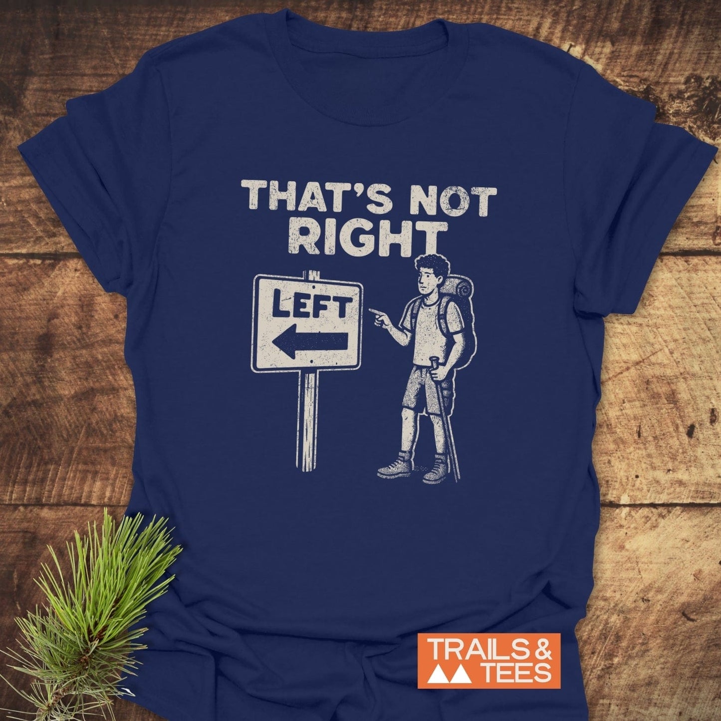 Navy That's Not Right T-shirt with a hiking pun, featuring a cartoon hiker and road sign, emphasizing outdoor adventure. Includes TRAILS & TEES logo.