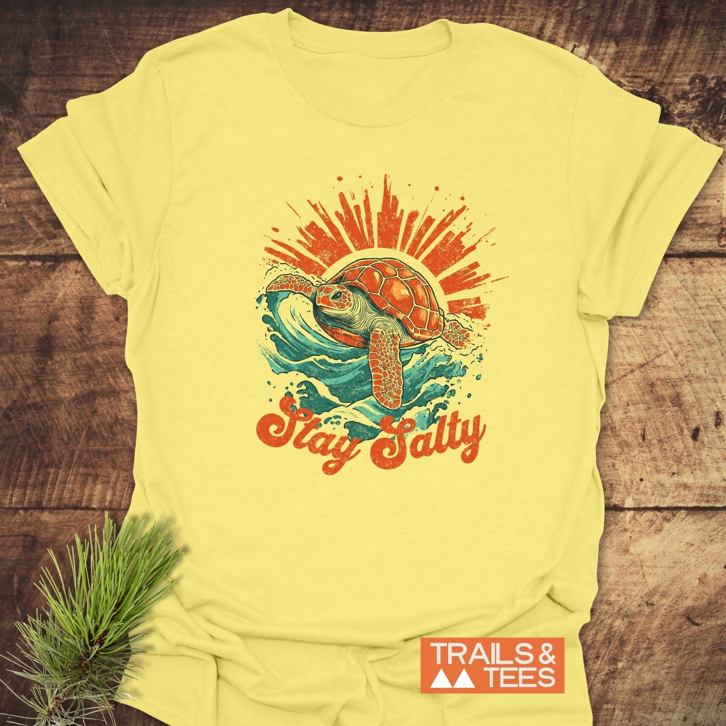 Stay Salty T-Shirt featuring a vintage sea turtle design on soft cotton, emphasizing comfort and adventure, with a Trails & Tees logo on the corner.
