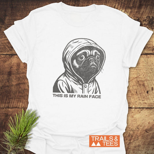 This Is My Rain Face T-Shirt featuring a pug in a hooded raincoat, crafted from soft ring-spun cotton by Trails & Tees.