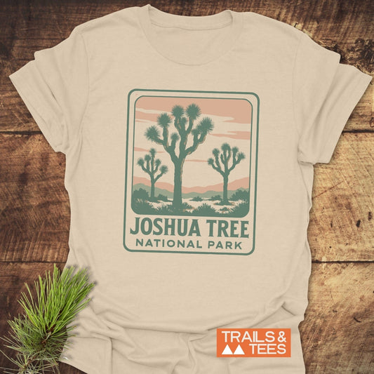 Vintage Joshua Tree NP T-Shirt with a stylized desert scene and durable prints, laid on wood. Made from soft cotton for everyday outdoor adventures.