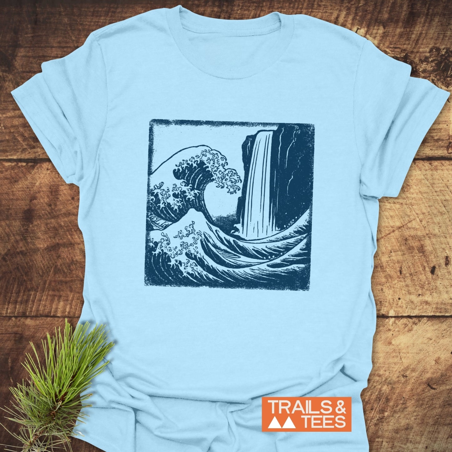 Waterfall And Wave T-Shirt featuring a two-tone graphic of a wave and waterfall, with TRAILS & TEES logo, showcasing comfort and durability for outdoor adventures.
