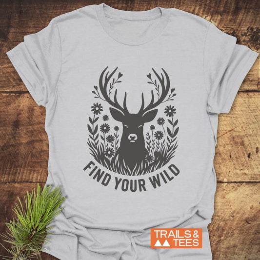 Find Your Wild T-Shirt featuring a deer silhouette with antler leaves and wildflowers, showcasing outdoor spirit. Made from soft, adventure-ready ring-spun cotton by Trails & Tees.