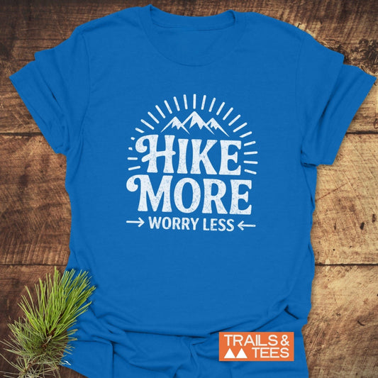 Hike More Worry Less T-Shirt with mountain graphic on blue, crafted from soft ring-spun cotton. Features durable prints, taped shoulders, and pre-shrunk fit.