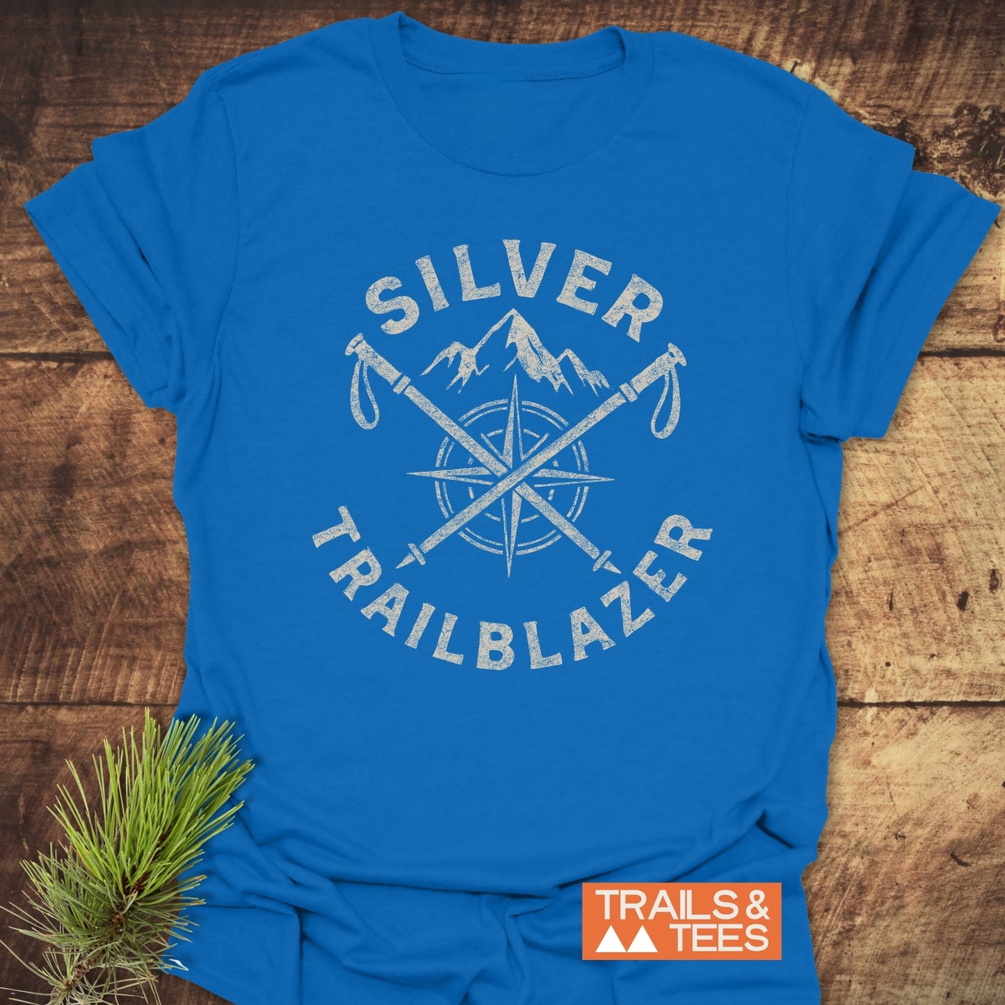 Silver Trailblazer T-Shirt with crossed hiking poles graphic on soft, lightweight cotton, ideal for outdoor enthusiasts. Features durable print and pre-shrunk fit.