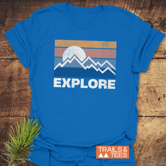 Explore Retro Sunset T-Shirt featuring a distressed graphic of stripes, sun, and mountains with EXPLORE text, showcasing outdoor spirit on soft, durable cotton.