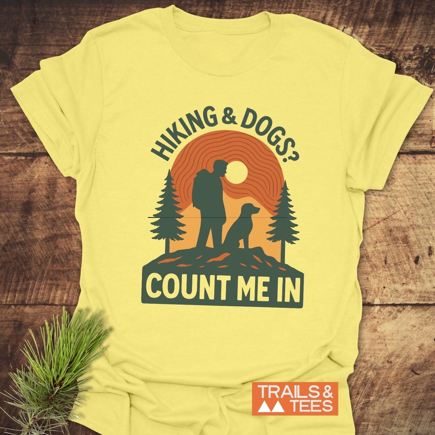 Hiking And Dogs T-Shirt featuring a retro hiker and dog graphic with pine trees and sunset, crafted from soft ring-spun cotton, designed for outdoor enthusiasts.