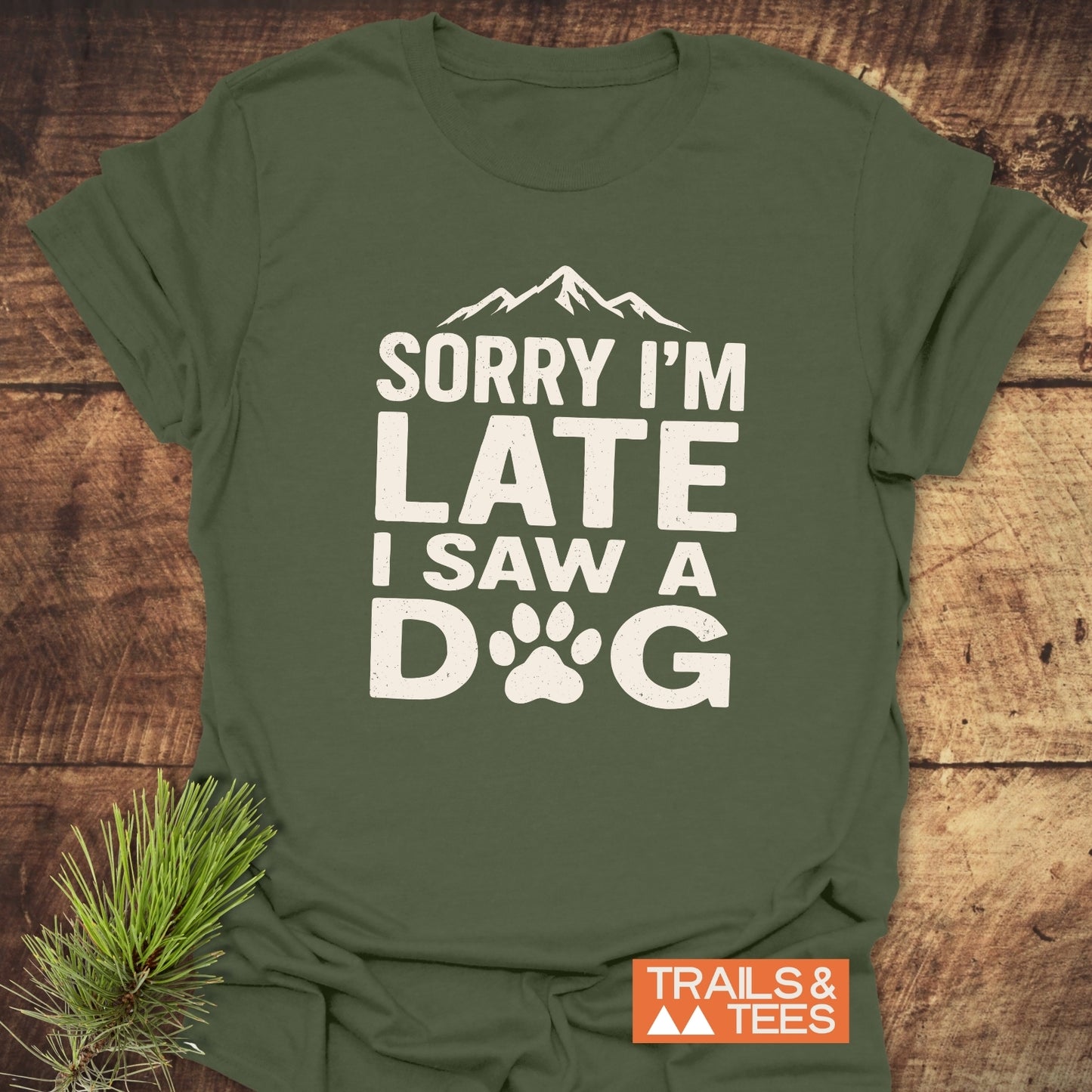 I Saw A Dog T-Shirt with mountain silhouette and paw-print graphic, crafted from soft cotton for comfort and durability, featuring Trails & Tees branding.
