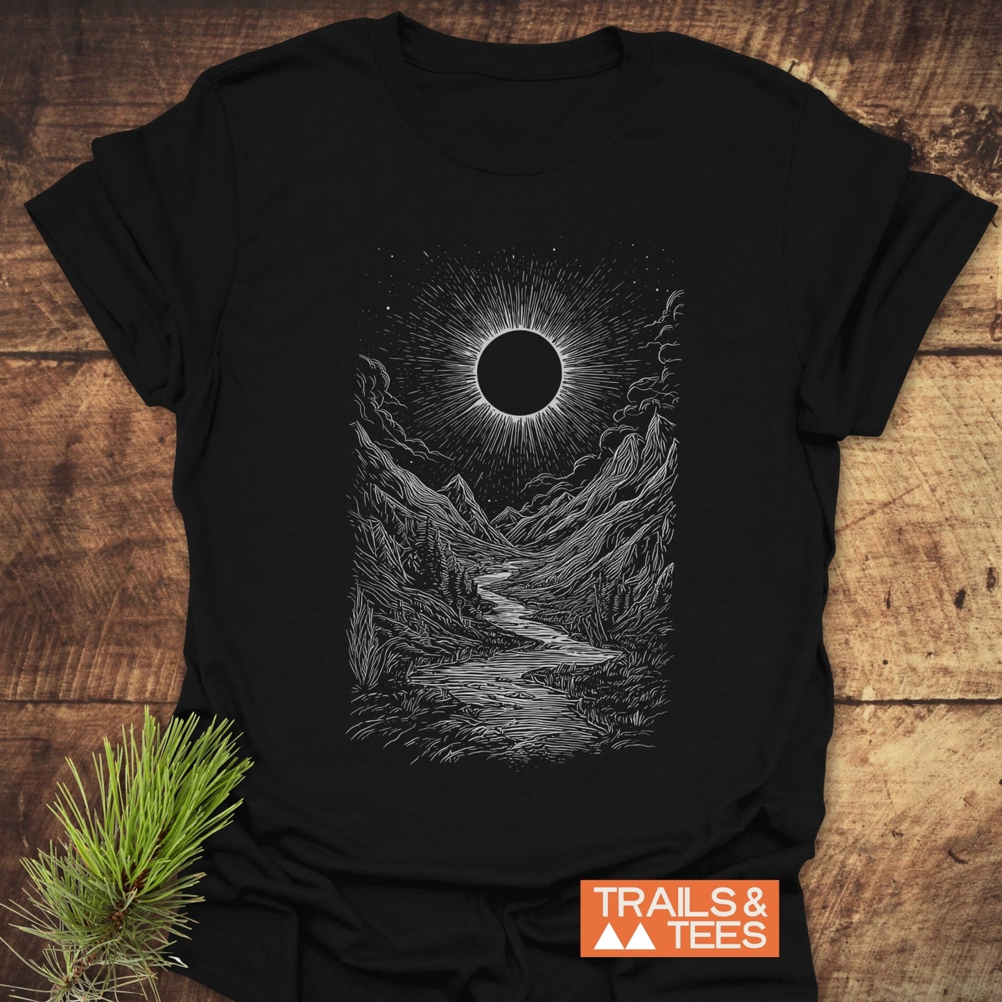 Eclipse Canyon T-Shirt featuring a white mountain valley scene with an eclipse on black fabric, highlighting adventure-ready, soft cotton comfort and durable print design.