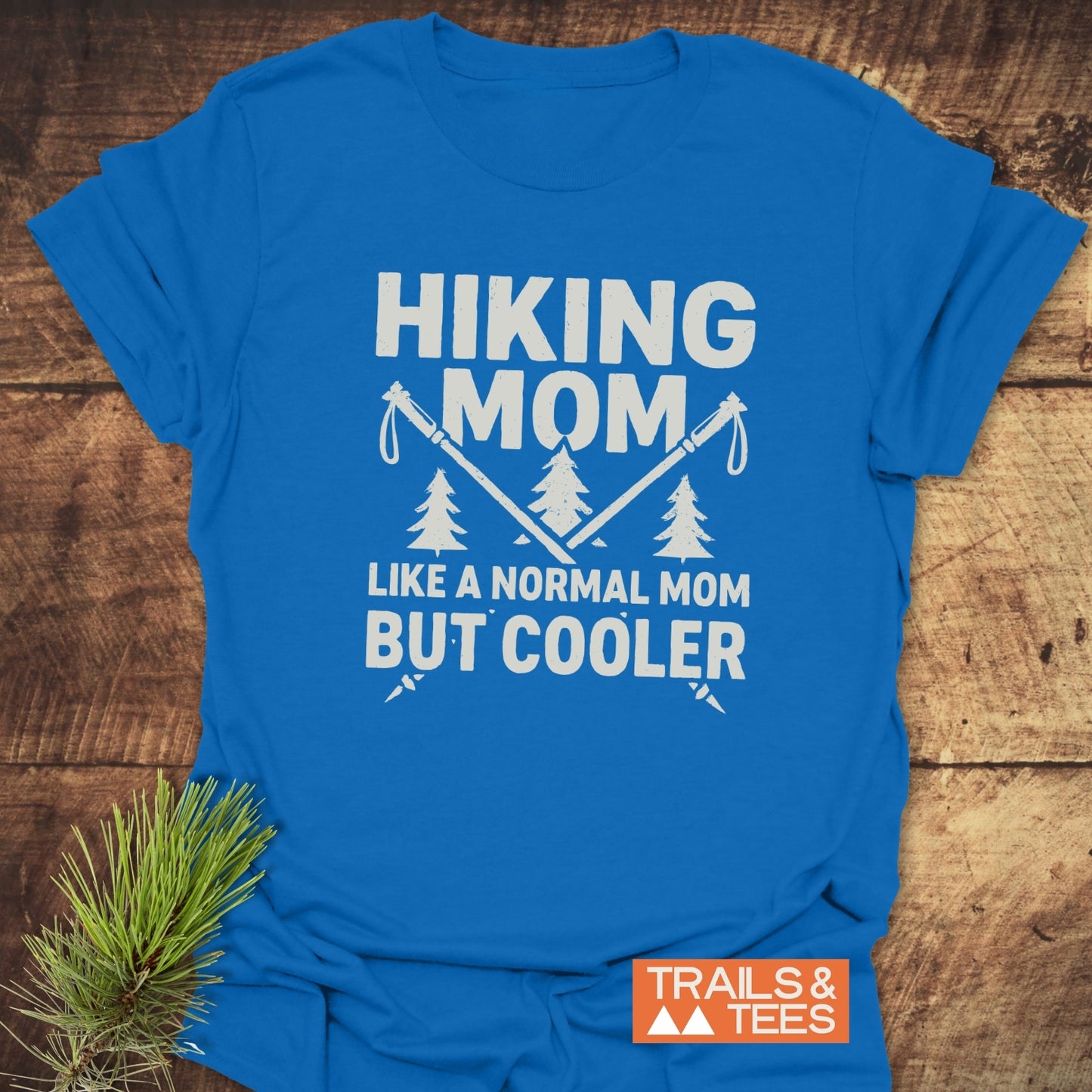 Hiking Mom T-Shirt with “HIKING MOM” and trekking poles design, crafted from soft, lightweight cotton for everyday adventure. Includes Trails & Tees logo.
