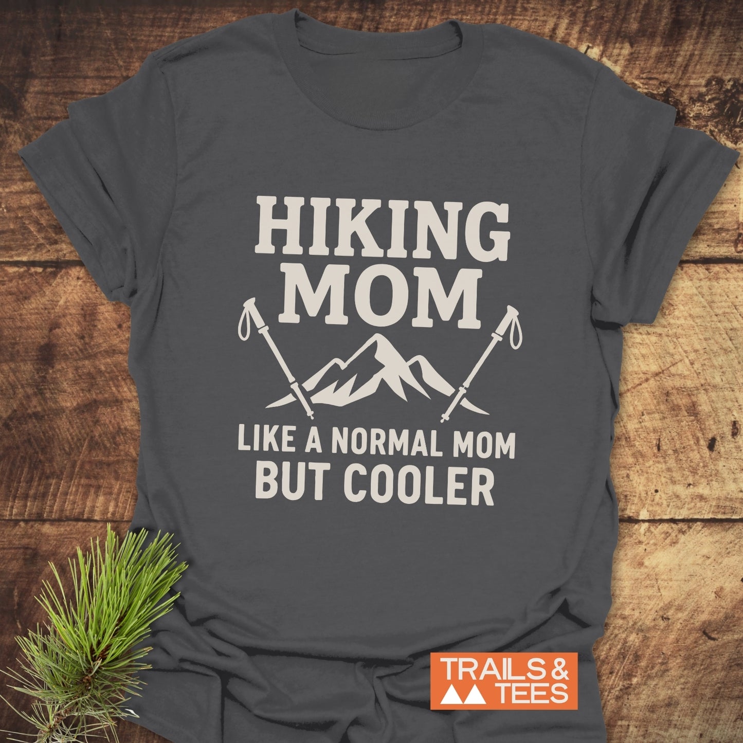 Dark-gray Hiking Mom T-Shirt with mountain graphic and text, laid flat. Made of soft ring-spun cotton, pre-shrunk for fit, featuring durable prints.