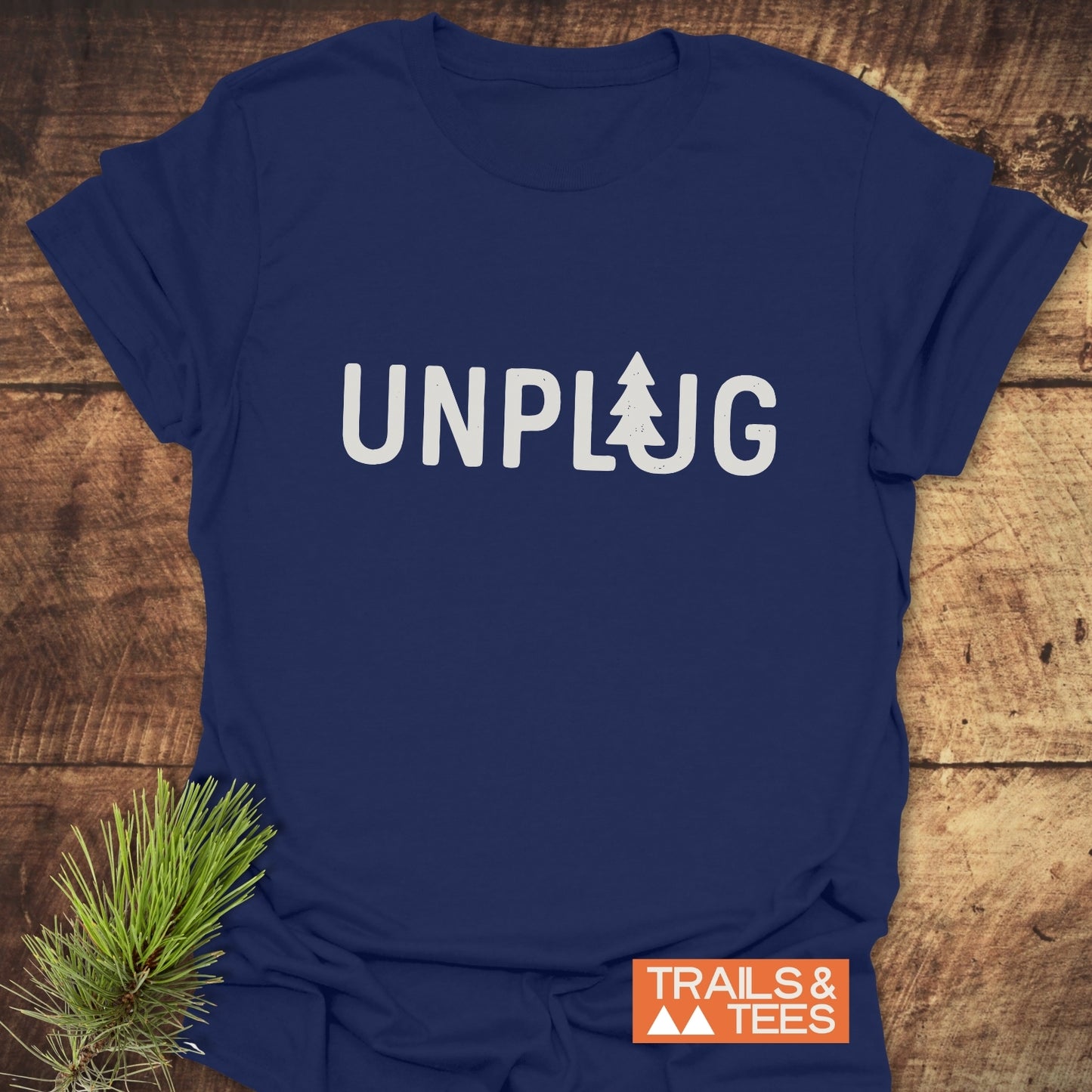 Unplug T-Shirt: Navy tee with UNPUG featuring a tree icon. Soft cotton, durable print. Perfect for outdoor enthusiasts.