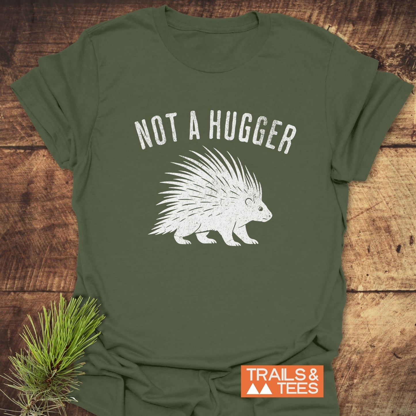 Not A Hugger T-Shirt with a vintage porcupine print, laid on wood. Features soft ring-spun cotton, pre-shrunk fit, and durable print.