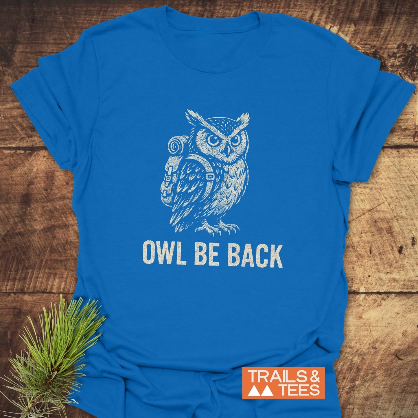 Owl Be Back Funny T-Shirt featuring an illustrated owl with a backpack and slogan, showcasing durable, comfortable design by Trails & Tees, perfect for outdoor enthusiasts.