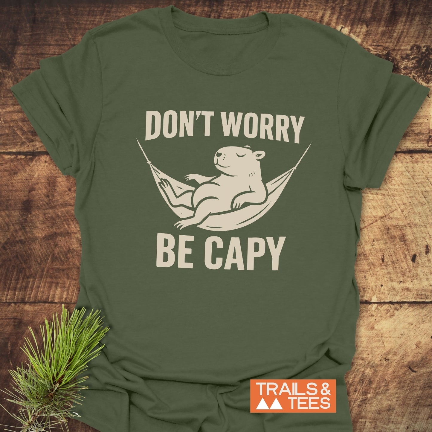 Don't Worry Capybara T-Shirt featuring a capybara in a hammock with the text DON’T WORRY BE CAPY, crafted from soft, durable cotton.