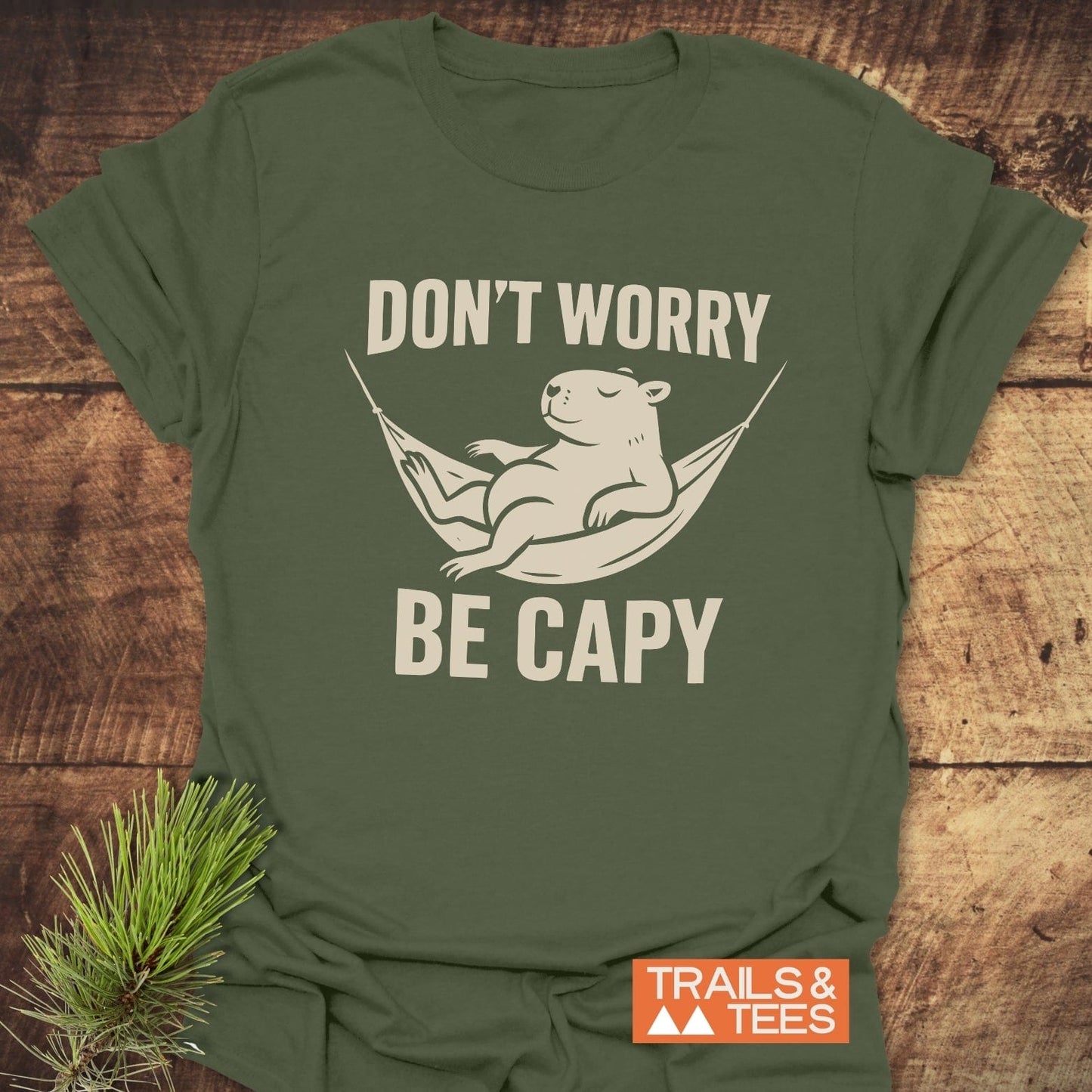 Don't Worry Capybara T-Shirt featuring a capybara in a hammock with the text DON’T WORRY BE CAPY, crafted from soft, durable cotton.