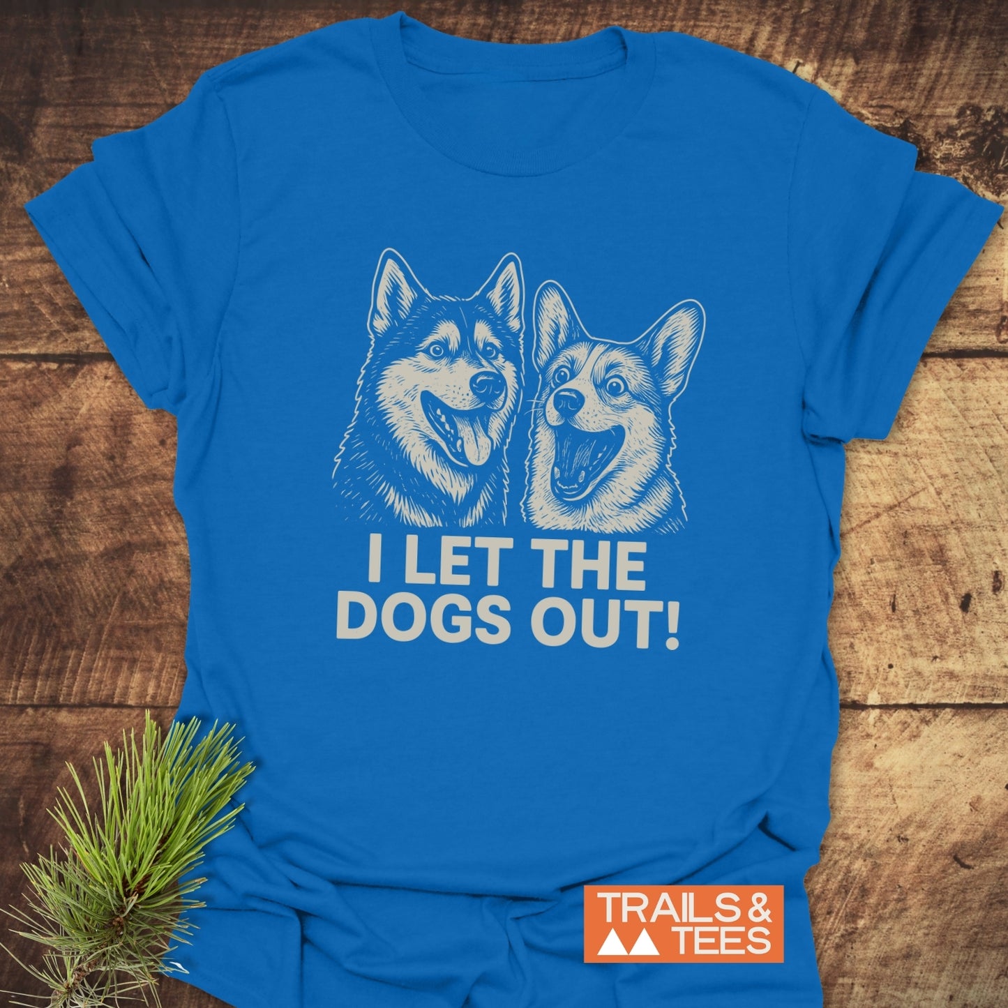 Royal-blue I Let The Dogs Out T-shirt with husky and corgi line-art, showcasing Trails & Tees logo, designed for comfort and durability.