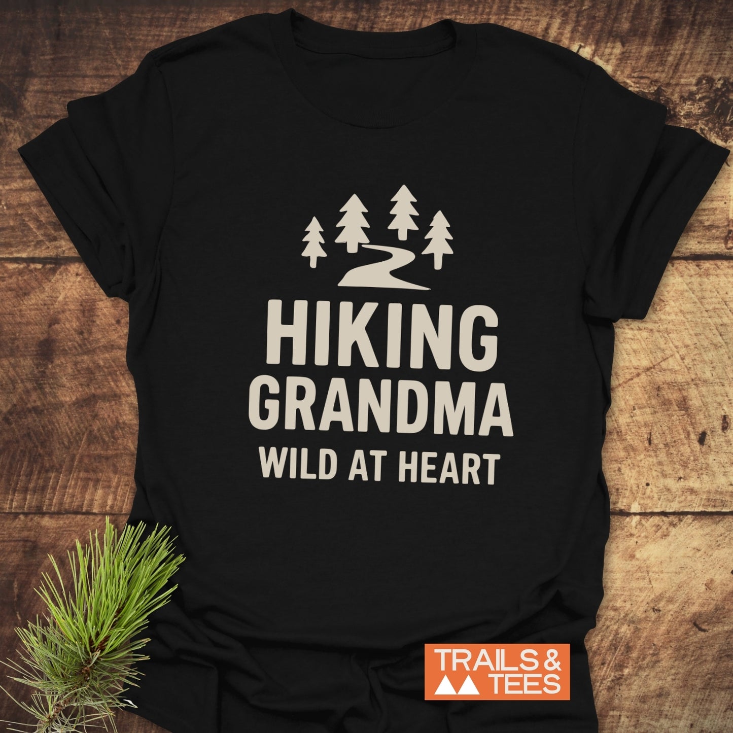 Hiking Grandma - Wild At Heart T-Shirt features evergreen trees and trail graphic, with durable prints on soft, pre-shrunk cotton, ideal for outdoor enthusiasts.
