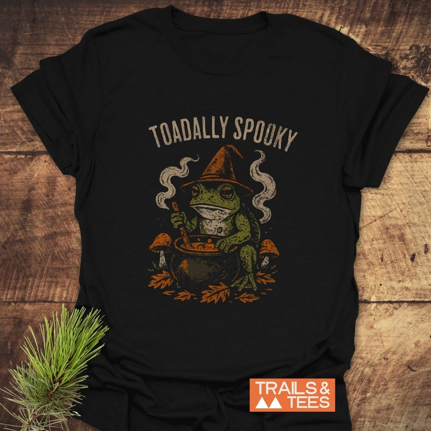 Toadally Spooky Halloween T-Shirt featuring a toad in a witch hat stirring a cauldron, designed with comfort and durability for outdoor adventures.