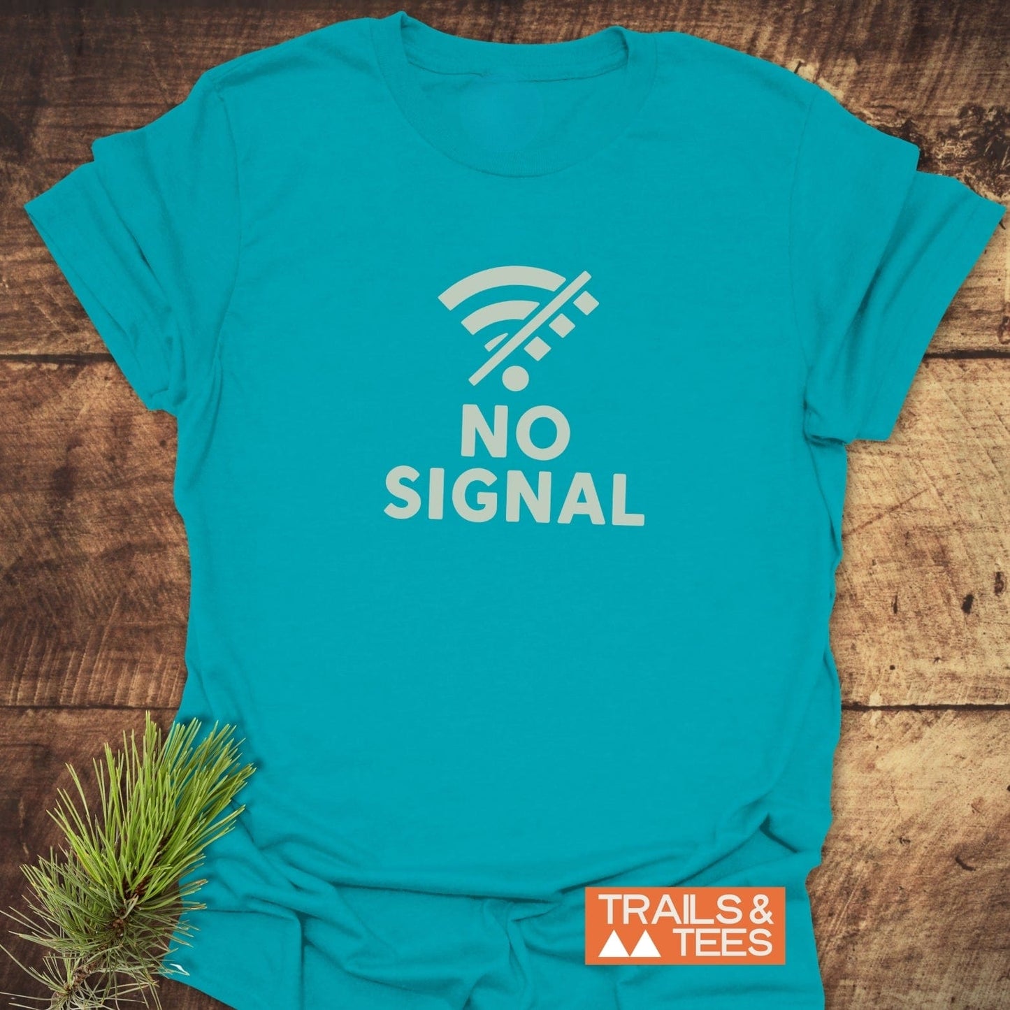 No Signal Minimalist T-Shirt featuring a crossed-out Wi-Fi icon and NO SIGNAL text, crafted from soft cotton with durable prints, laid on a wooden surface.