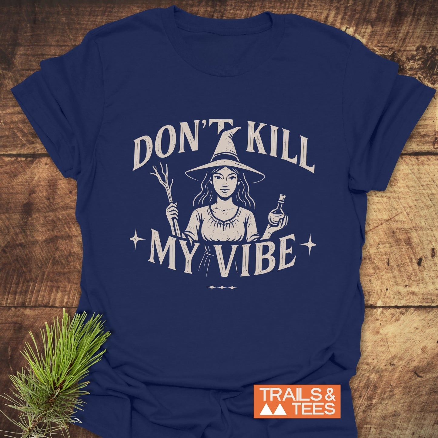 Don't Kill My Vibe Wood Witch T-Shirt with witch graphic, ring-spun cotton, DTF print, and Trails & Tees logo, styled with pine sprig.