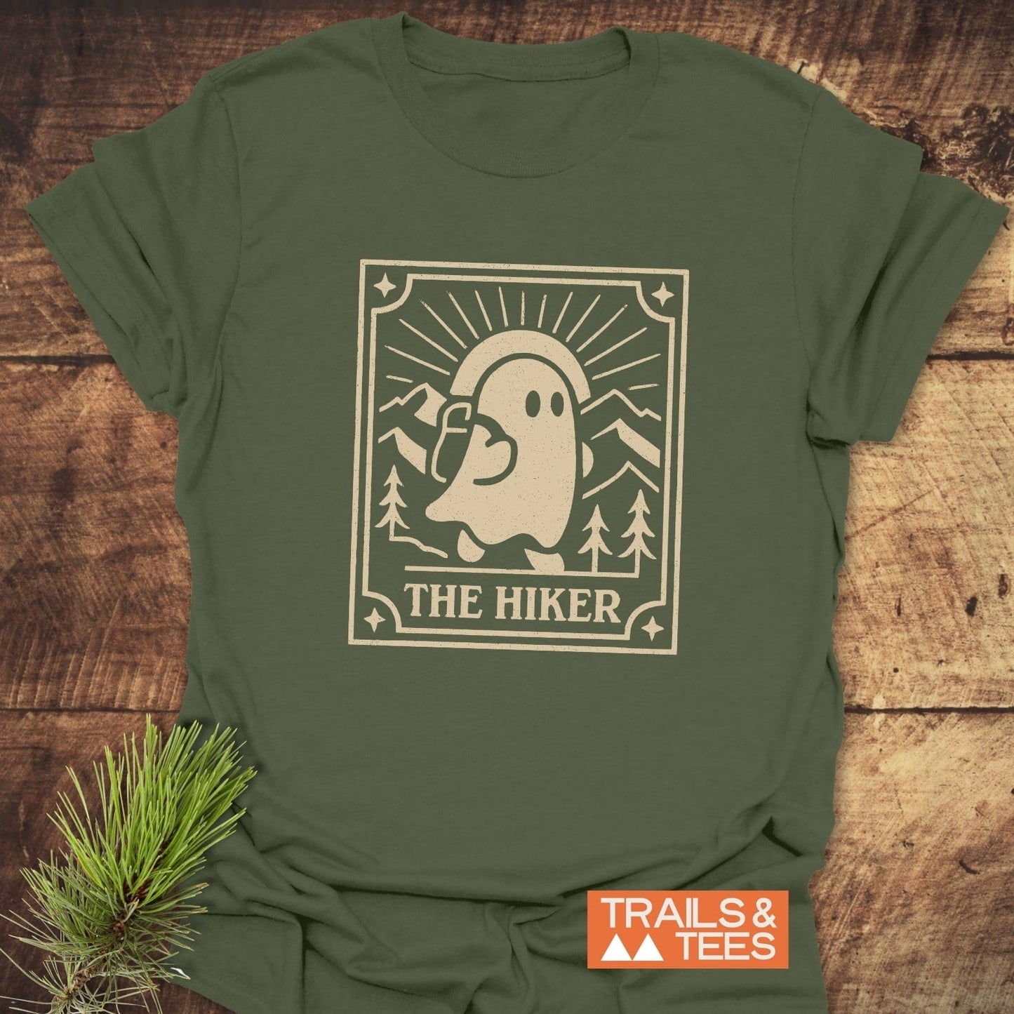 The Hiker Retro Tarot T-Shirt features a ghostly hiker illustration on a faded-olive tee, emphasizing outdoor adventure and comfort with durable, eco-friendly print.