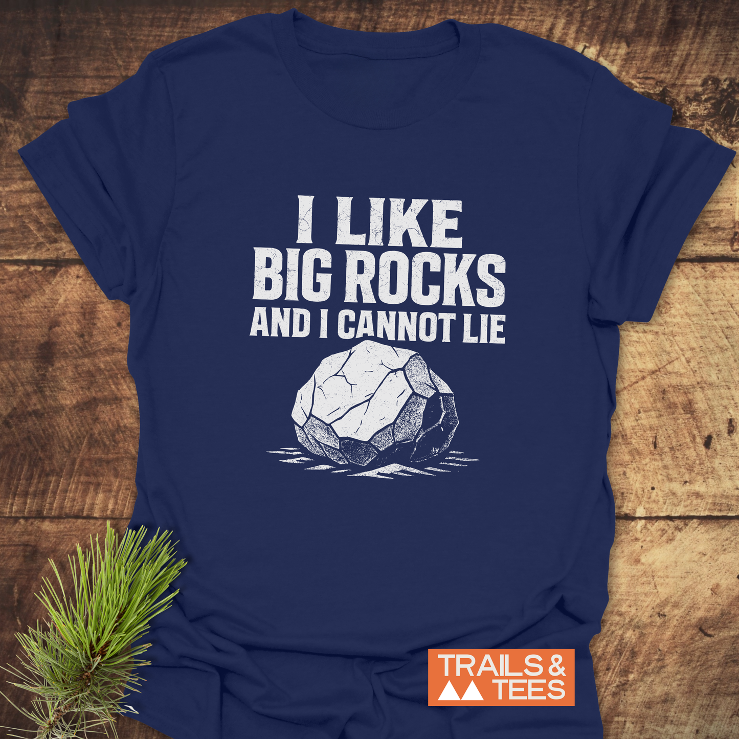Navy-blue T-shirt with I LIKE BIG ROCKS AND I CANNOT LIE graphic, showcasing durability and comfort from Trails & Tees.