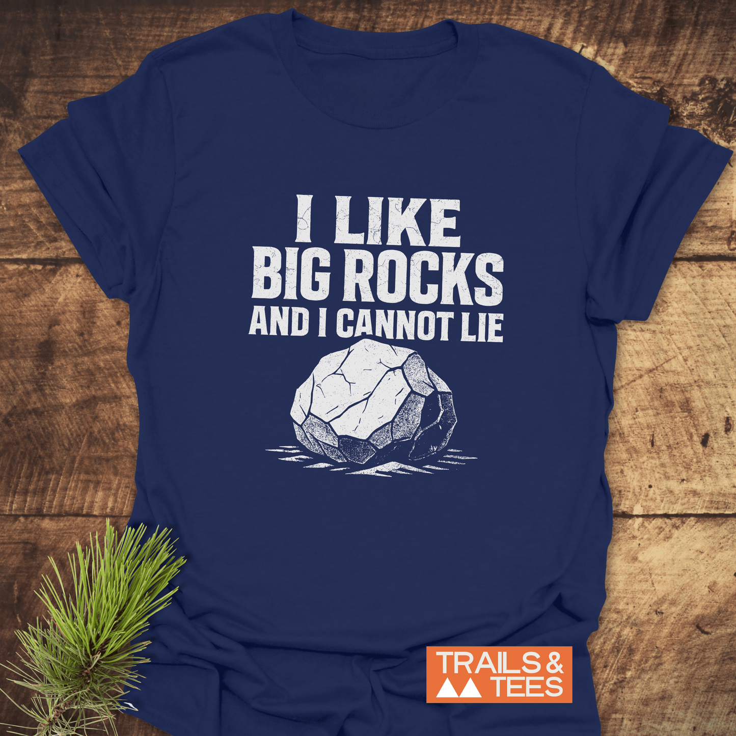 Navy-blue T-shirt with I LIKE BIG ROCKS AND I CANNOT LIE graphic, showcasing durability and comfort from Trails & Tees.