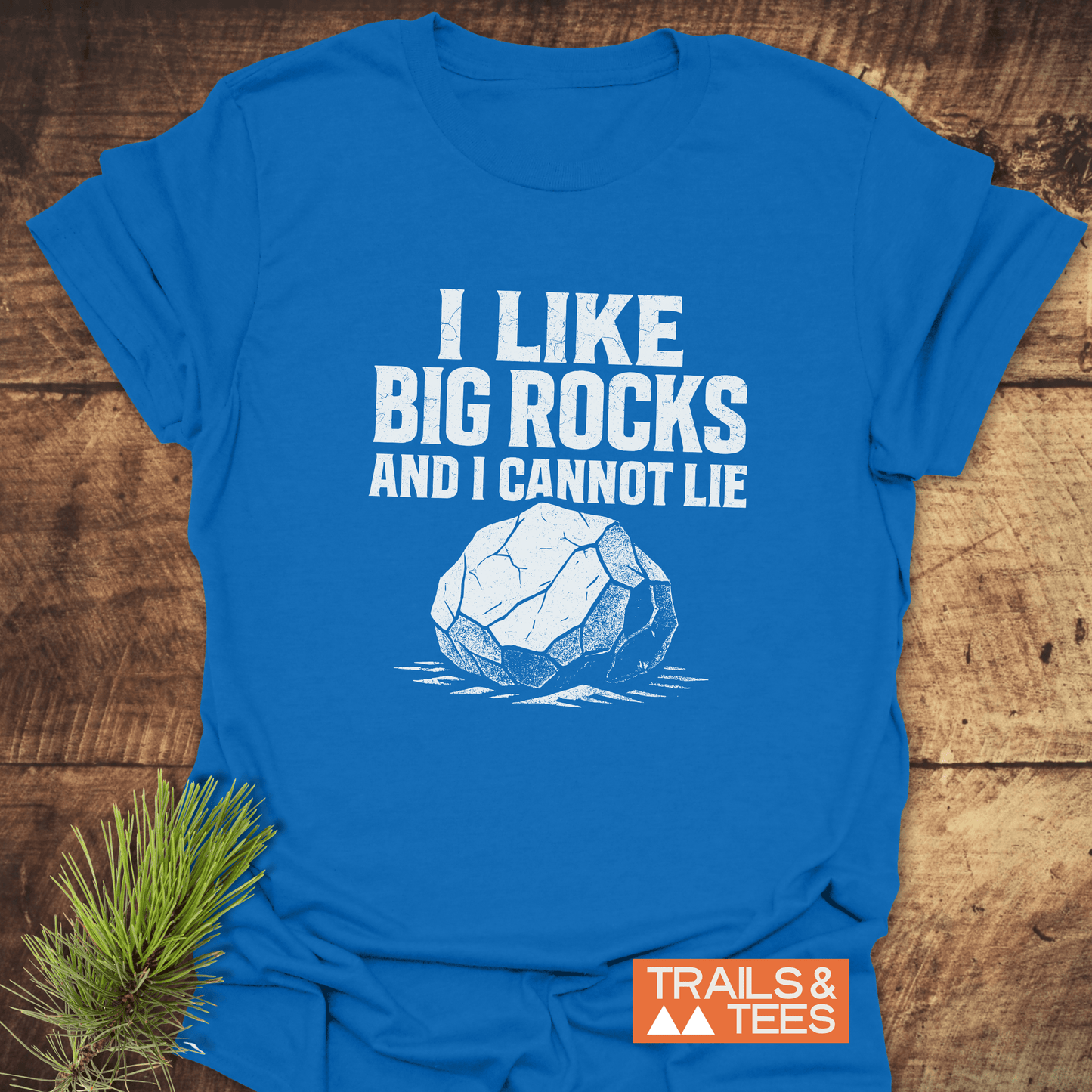 I Like Big Rocks Funny T-Shirt, featuring bold text and rock graphic, made from soft ring-spun cotton, includes “TRAILS & TEES” logo.
