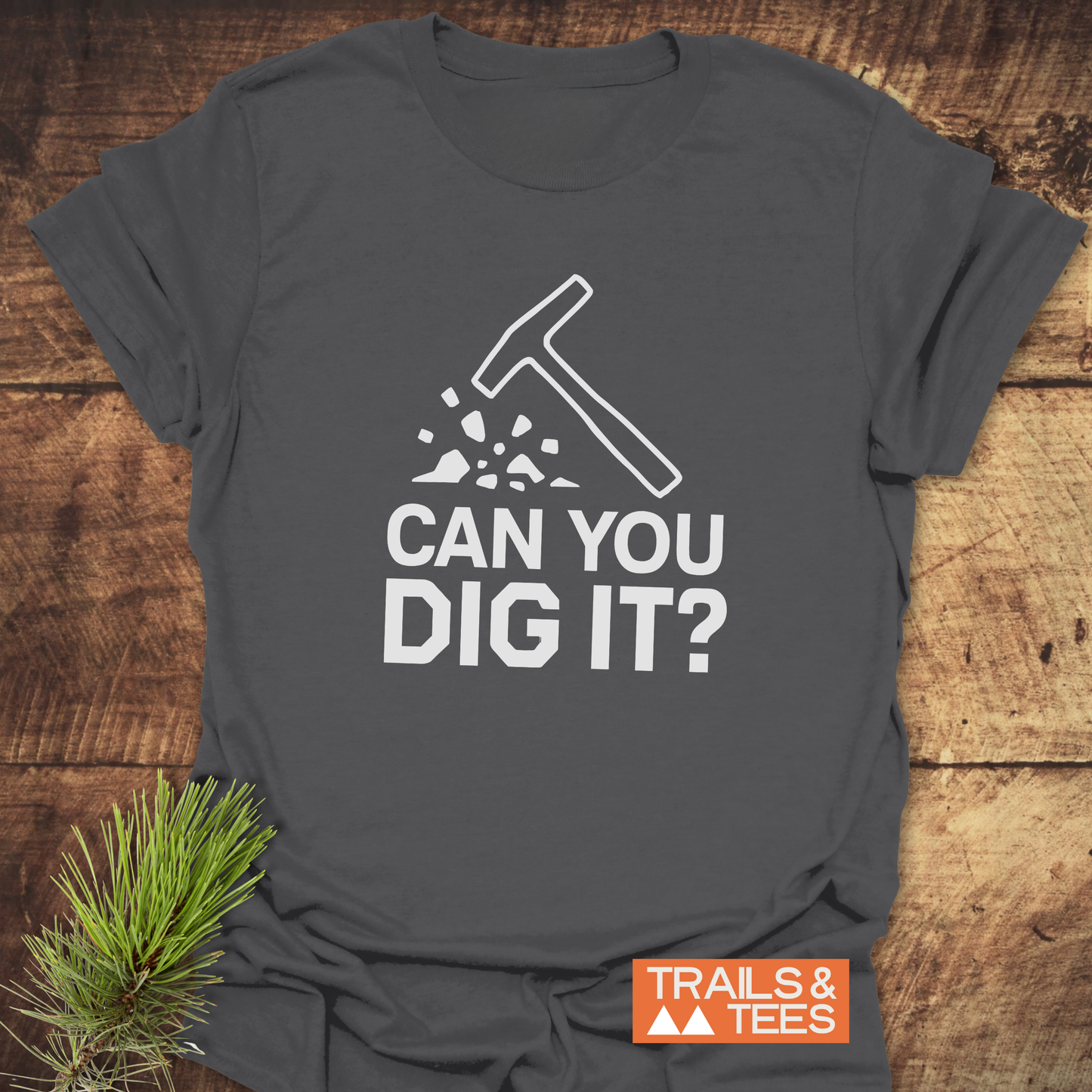 Can You Dig It? Rock Lovers T-Shirt featuring a hammer graphic, made from soft cotton for comfort and adventure, laid on a wooden surface.