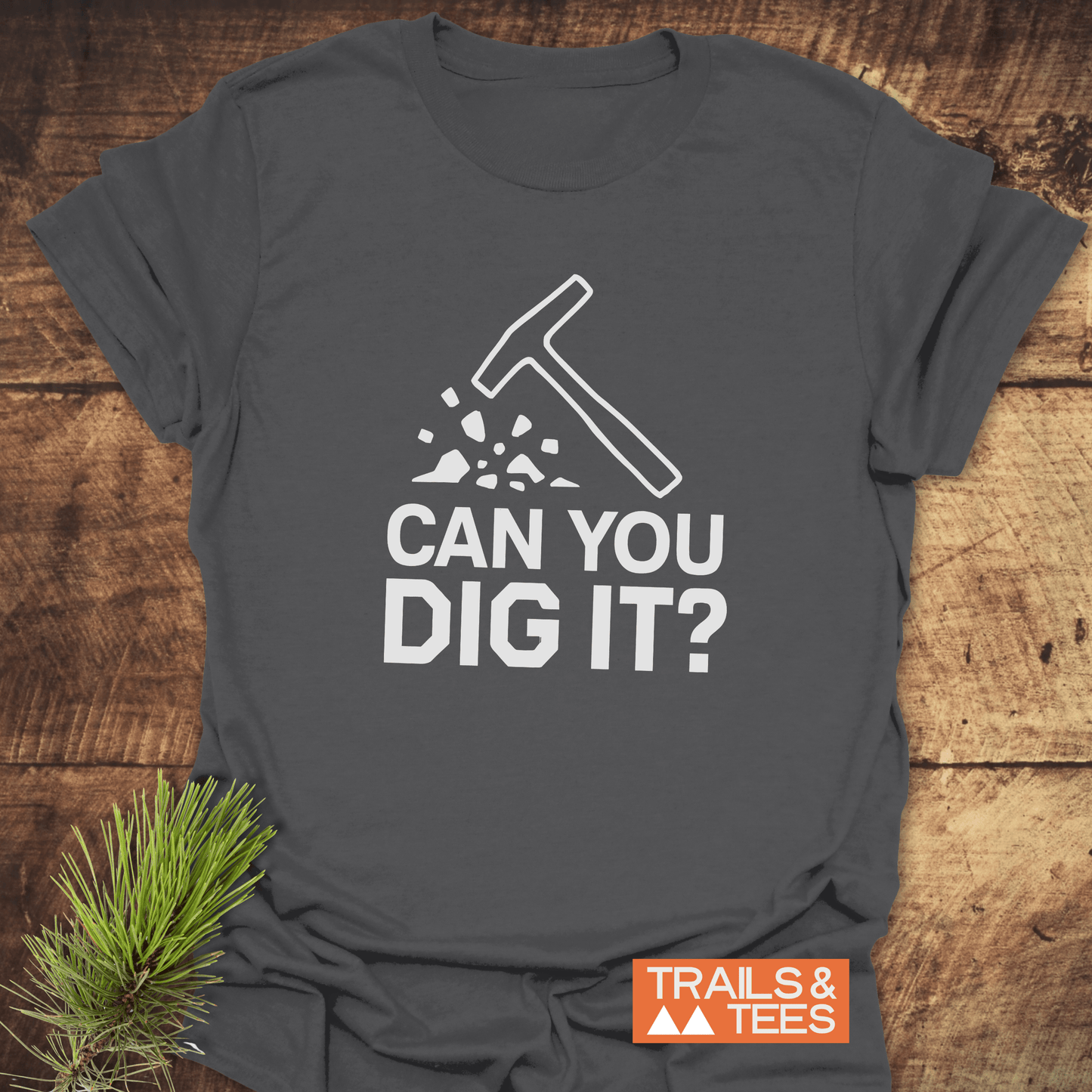 Can You Dig It? Rock Lovers T-Shirt featuring a hammer graphic, made from soft cotton for comfort and adventure, laid on a wooden surface.