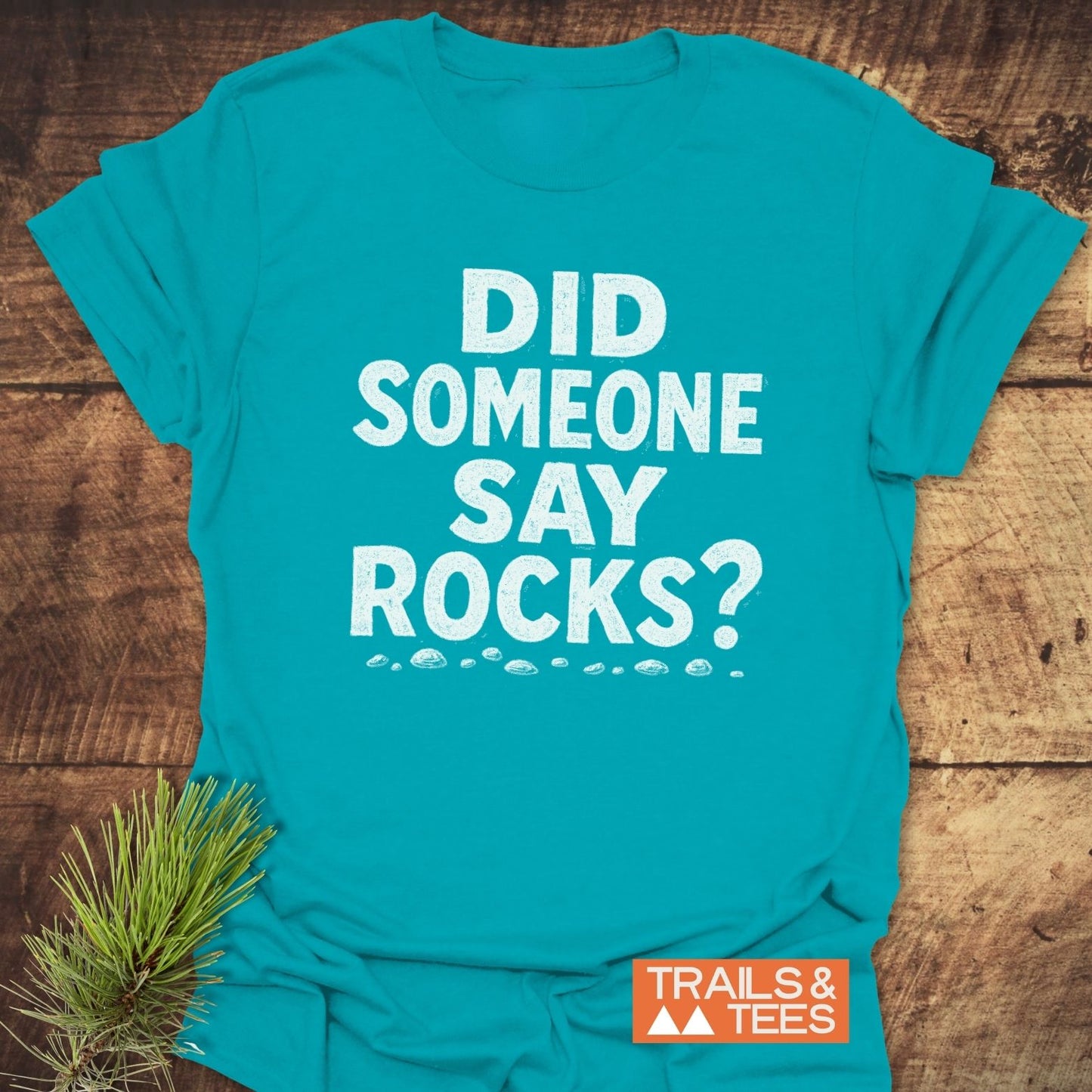 Did Someone Say Rocks? T-Shirt featuring bold white text, stone icons, and a Trails & Tees logo, made from soft, durable, pre-shrunk cotton.