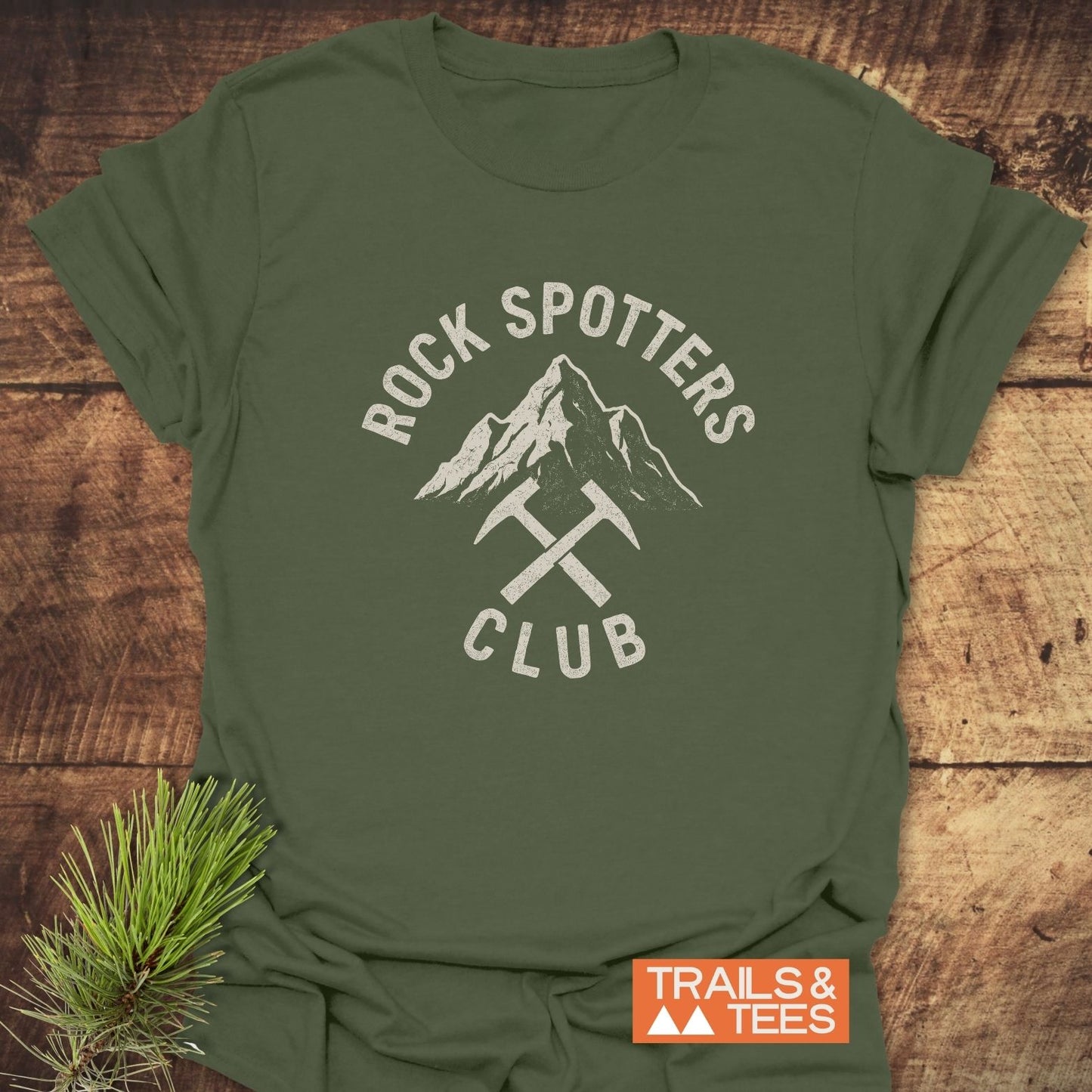 Rock Spotters Club T-Shirt featuring a mountain peak and rock-hammers graphic, crafted from soft cotton for comfort, perfect for outdoor enthusiasts.