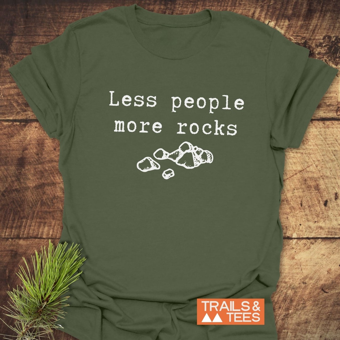 Olive-green Less People More Rocks T-shirt with typewriter text and rock drawing, featuring soft cotton, durable prints, and TRAILS & TEES logo.