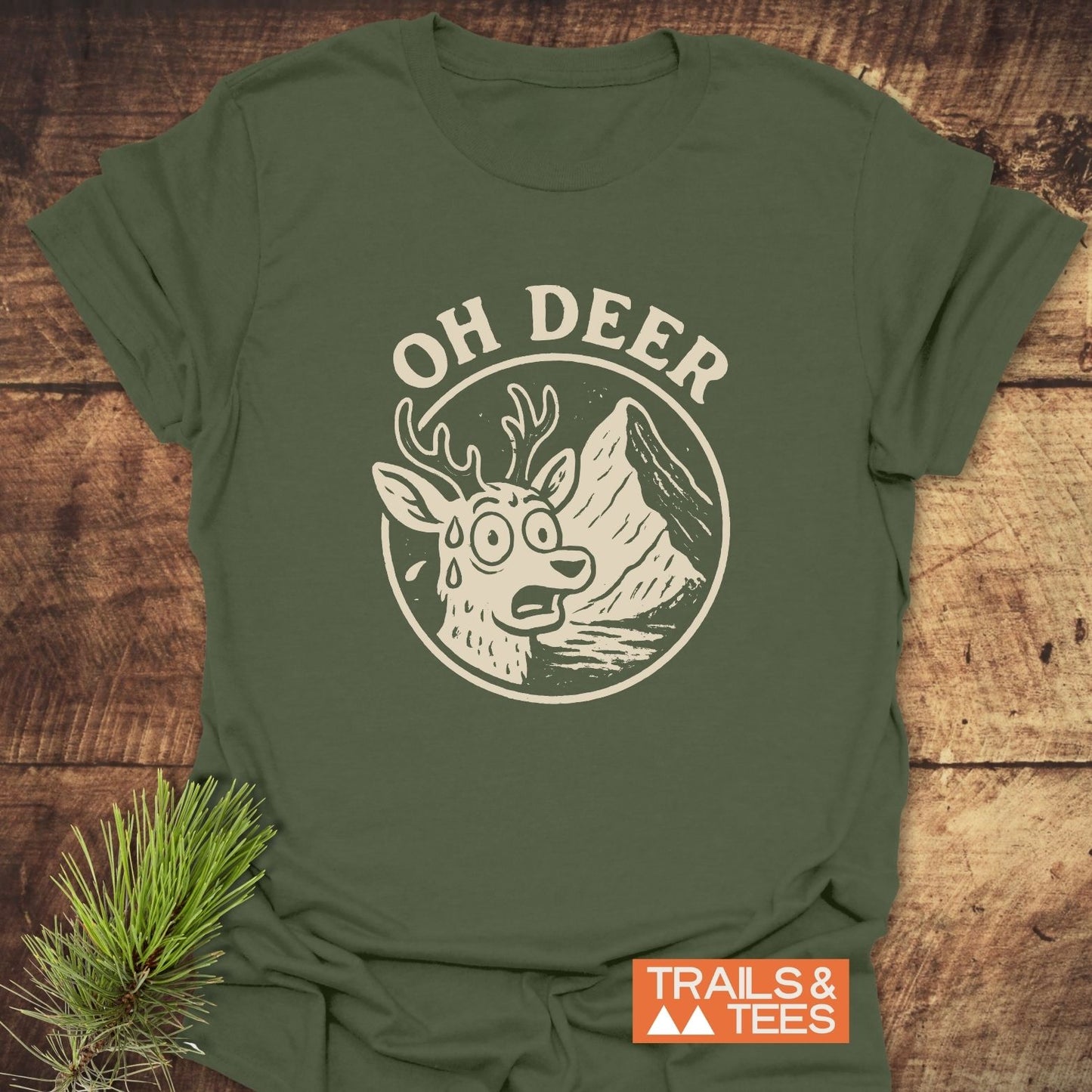 Oh Deer Funny Hiking T-Shirt featuring a vintage-style graphic of a sweating deer and mountain scene, with TRAILS & TEES logo on an olive-green background.