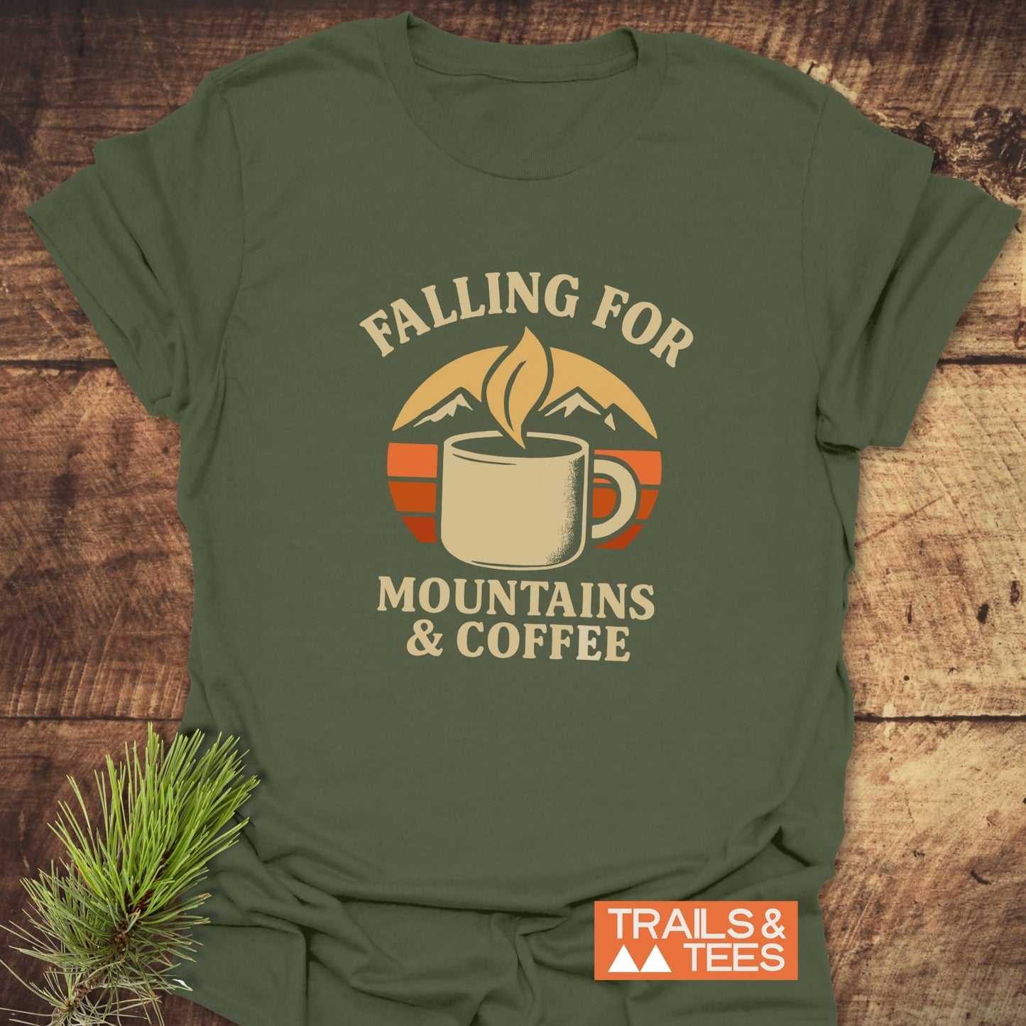 Falling For T-Shirt featuring a retro coffee and mountain graphic, highlighting adventure and comfort in soft ring-spun cotton, with a small Trails & Tees logo.