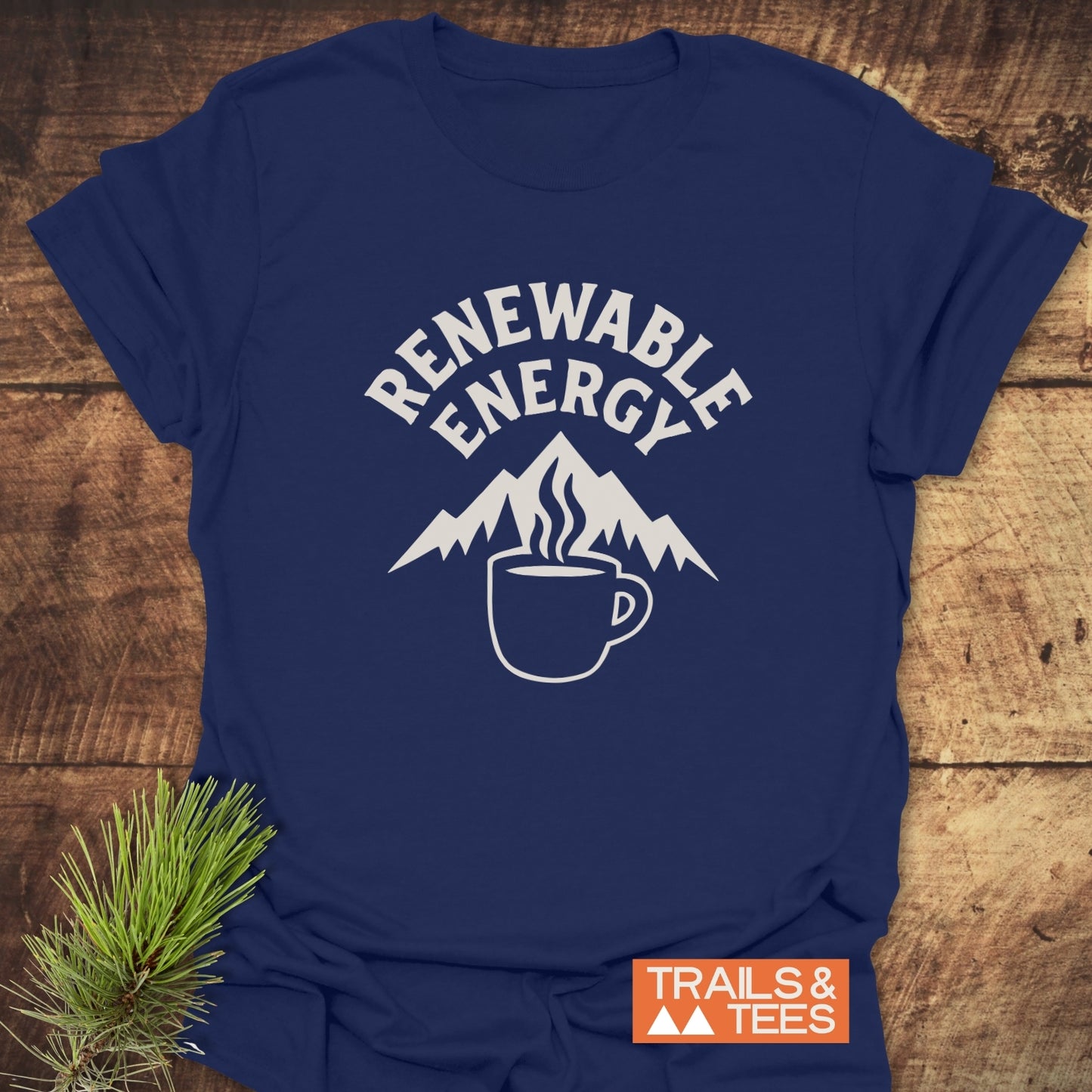 Renewable Energy T-Shirt featuring mountain and coffee mug graphic, emphasizing outdoor adventure. Made from soft, durable cotton with a TRAILS & TEES logo.