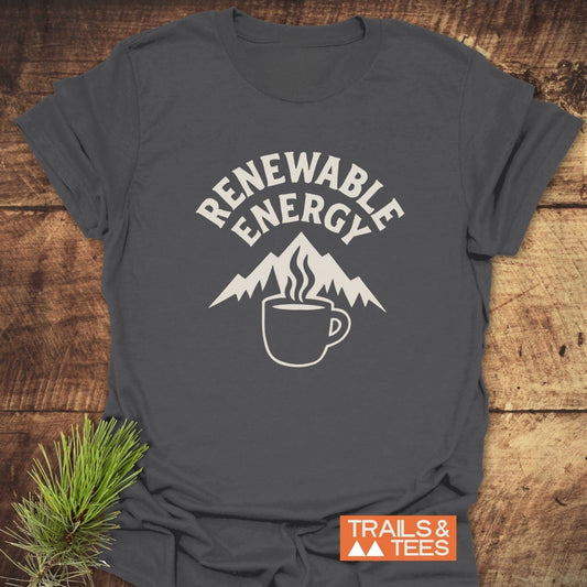 Charcoal-gray Renewable Energy T-Shirt featuring a mountain and coffee mug design, orange Trails & Tees logo tag, with a pine sprig accent.