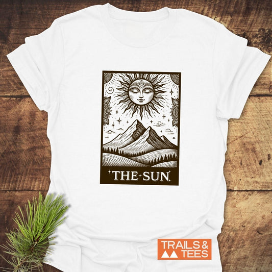 The Sun Tarot T-Shirt featuring a radiant sun graphic above mountains, crafted from soft cotton for everyday outdoor adventures, durable and pre-shrunk for reliability.