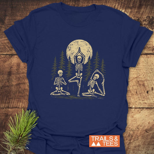 Relax In The Woods T-Shirt featuring skeletons in yoga poses amid pine trees and moon, crafted from soft cotton for comfort and durability.