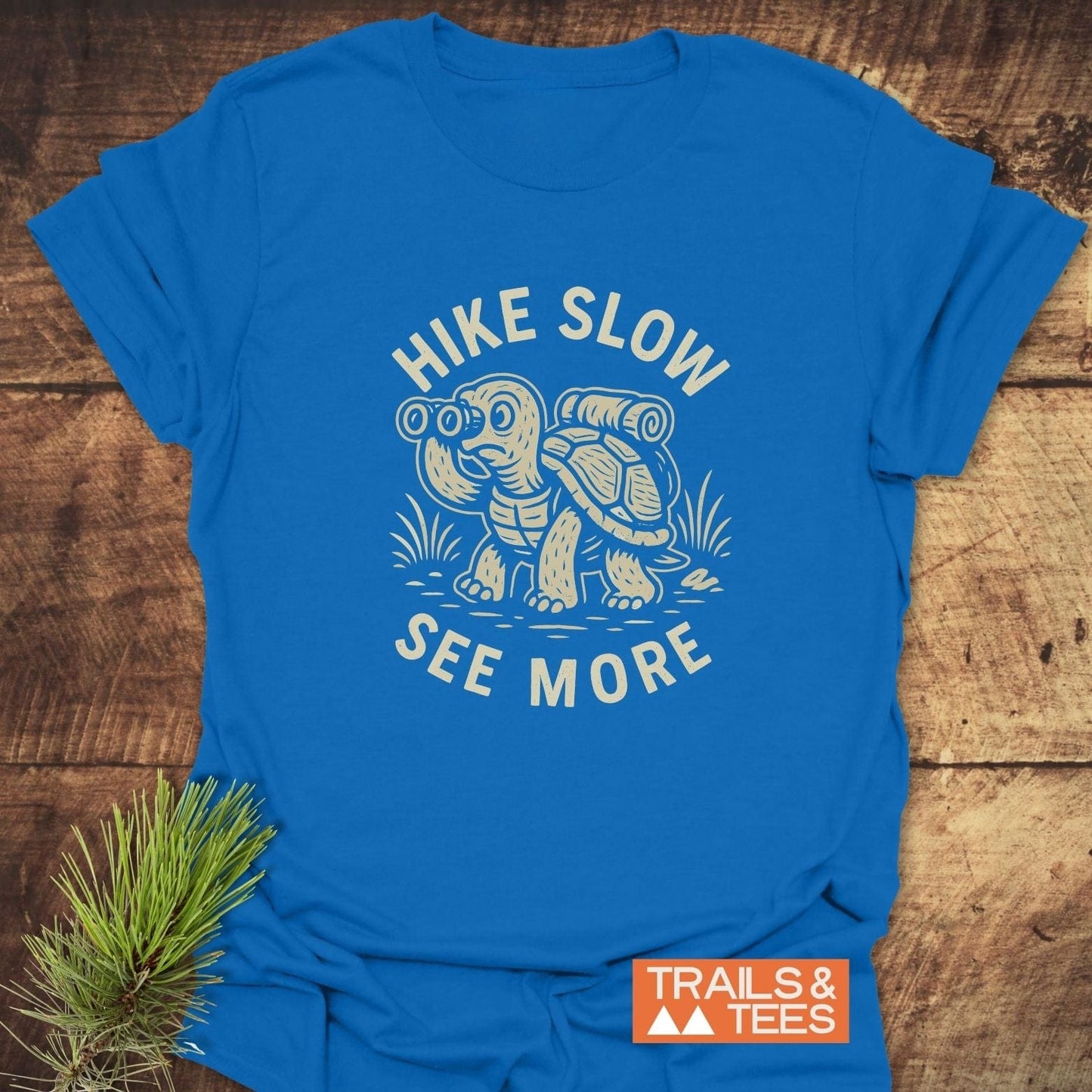 Hike Slow Funny T-Shirt featuring a turtle with a backpack and binoculars. Made from soft, ring-spun cotton, offering comfort and durability for outdoor enthusiasts.