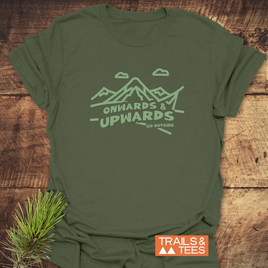 Go Outside T-Shirt featuring a mountain scene and slogans on an olive-green fabric, showcasing durability and comfort, alongside a Trails & Tees logo and pine sprig.