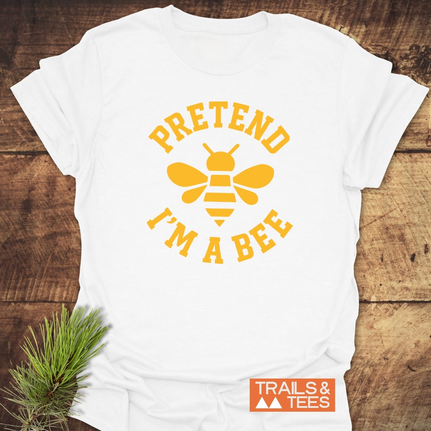 I'm A Bee Funny T-Shirt with a yellow bee graphic and text, laid on wood. Features soft cotton, durable print, pre-shrunk for a relaxed fit.